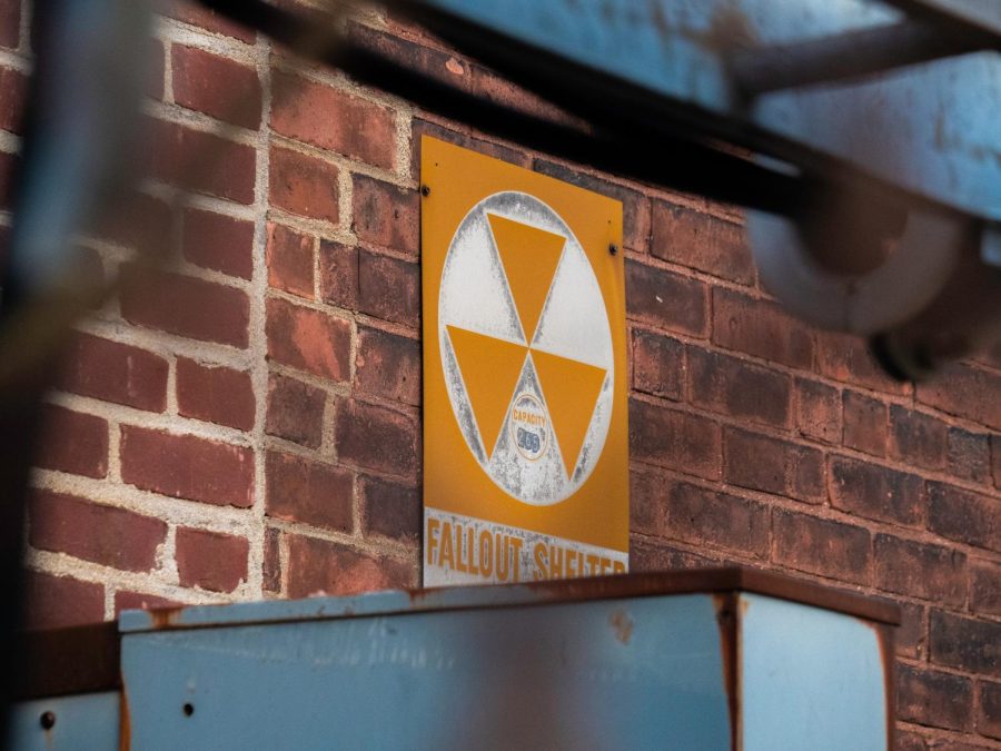 A fallout shelter sign labeling the location of one in the building. The six wedges symbolize shielding from radiation, food and water, trained leadership, medical supplies and aid, communications with the outside world, and radiological monitoring to determine safe areas.
