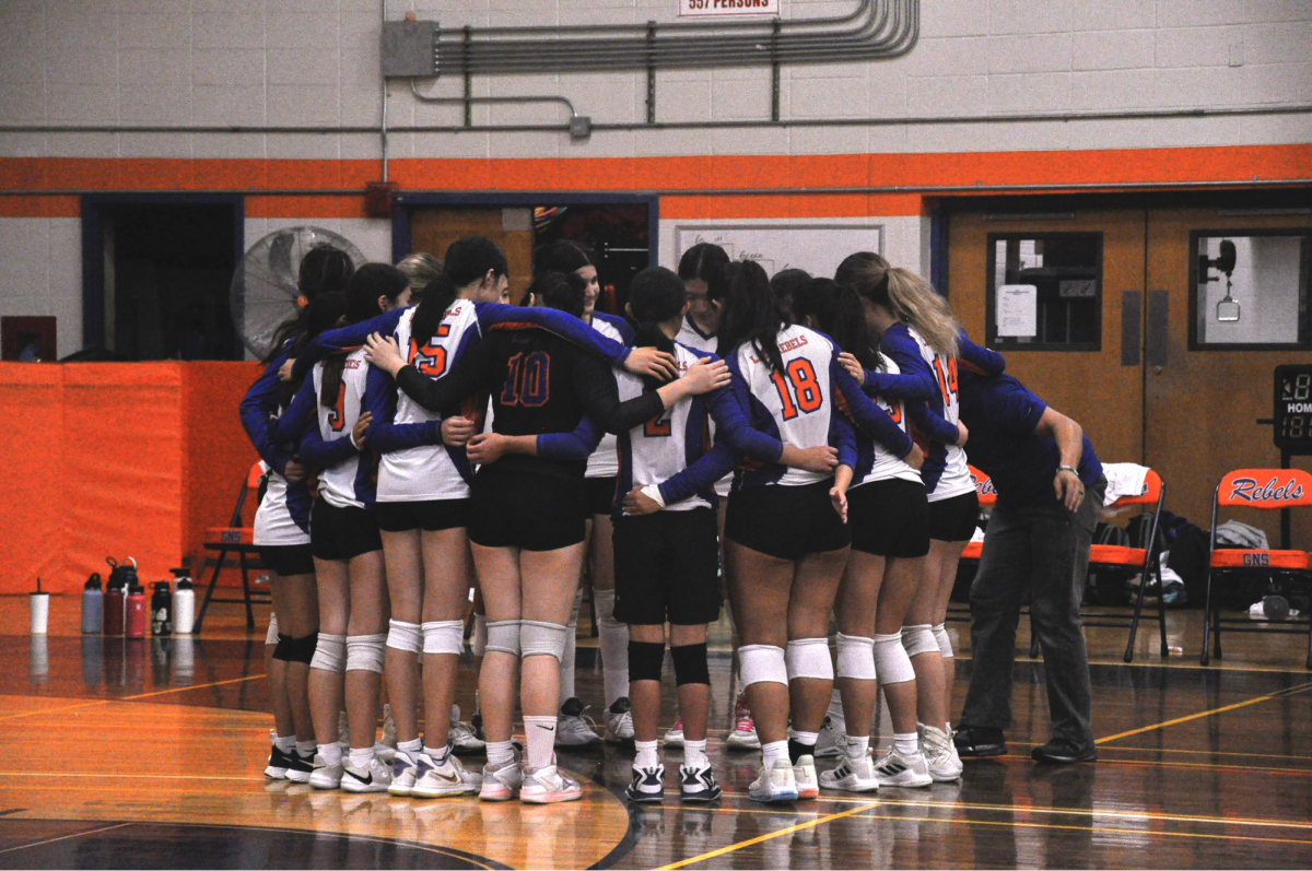 The+Girls+Volleyball+Team+in+a+team+huddle+before+their+3-0+victory+against+Westbury+on+October+4th%2C+2023.+The+girls+ended+off+their+season+with+a+14-0+undefeated+record+in+their+conference.
