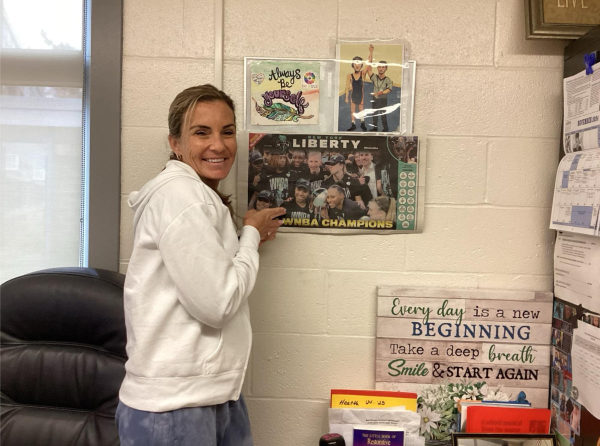 “During the (WNBA) championship this year, it was awesome to see the stadium sold out”—Dean of Students Ms. Tara Schiereck smiles next to her beloved New York Liberty poster. Schiereck, who played division II basketball herself at Adelphi University, is a loyal New York Liberty fan.