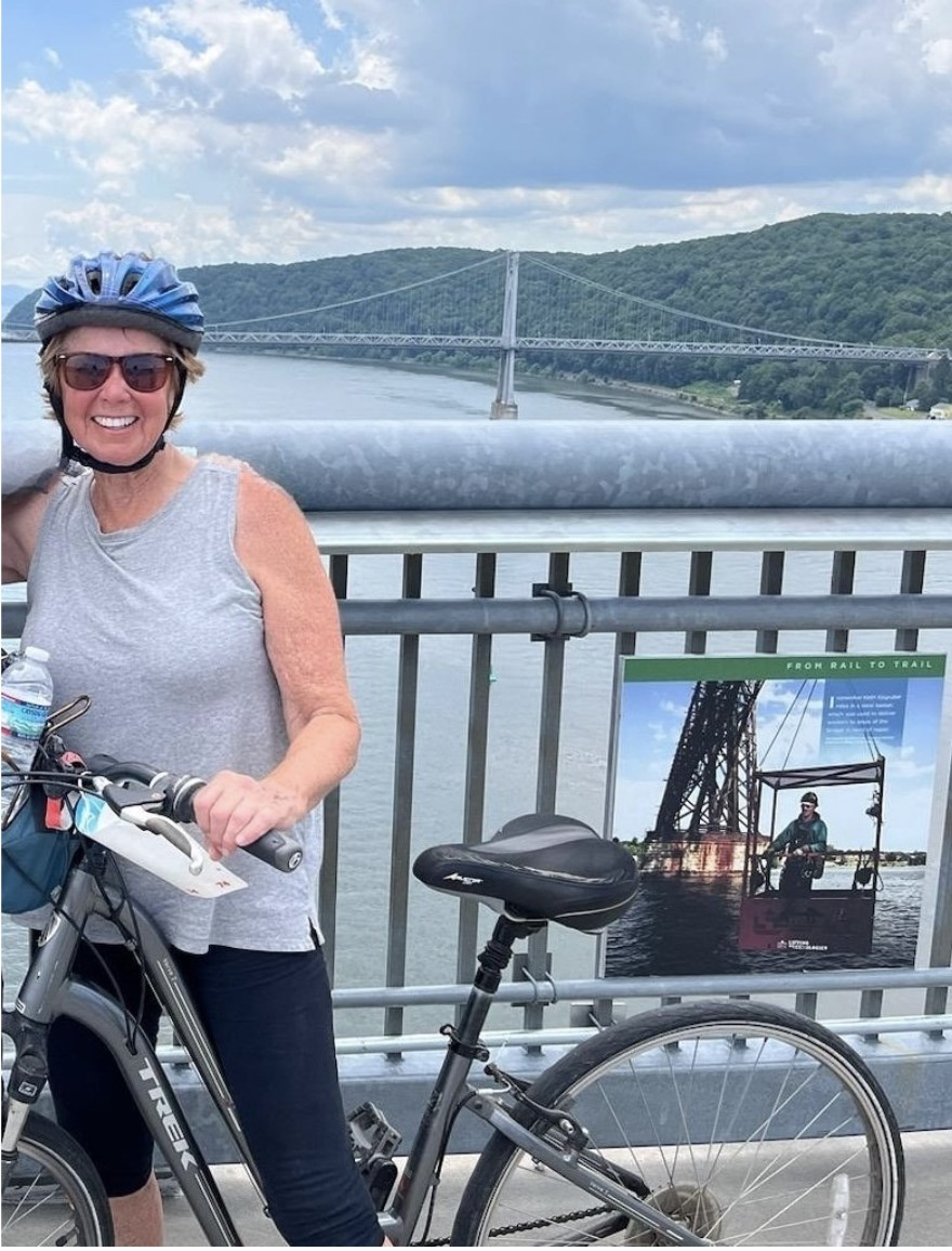 Ride and Shine—Mrs. Callaghan strikes a pose with her bike on the Walkway Over the Hudson State Park. Each year, she and her son make a tradition of visiting Poughkeepsie, New York, to enjoy a biking adventure together.